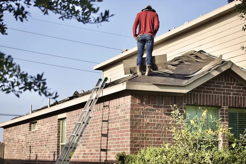 Professional roofer working on a residential roof in East Lake Village